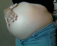 Her friend rubbing her pregnant belly