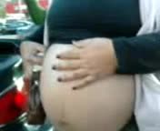 Pregnant woman at her car.